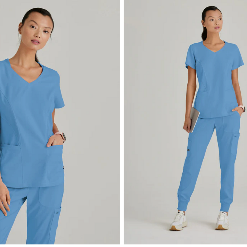 
                  
                    Top de Grey's Anatomy, modelo GRST124, con cuello en V curvo y 3 bolsillos, diseñado para combinar estilo y funcionalidad para profesionales de la salud.
                  
                